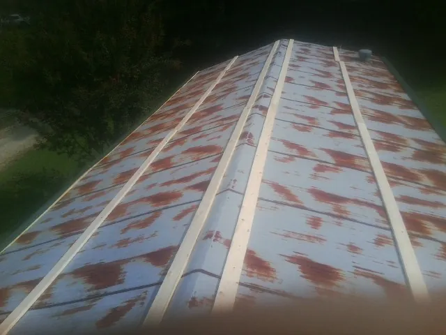 Rusted metal roof panels with new wood purlins before replacement — Storm Damage Roof Repair in Glenville by Roofing Brothers